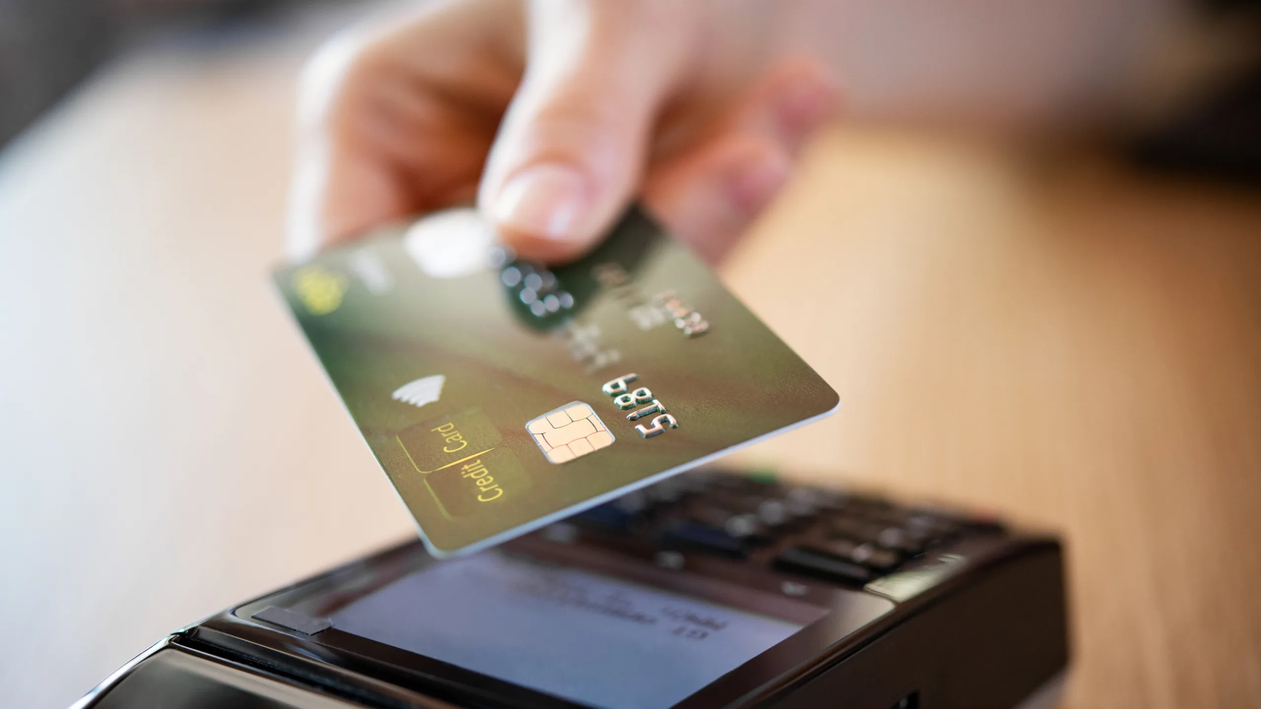 A payment card resting on a point-of-sale terminal, representing healthcare payment processing